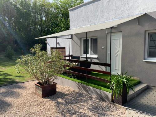 a house with a porch with plants in front of it at Mineral apartman Smaragd in Nyíregyháza