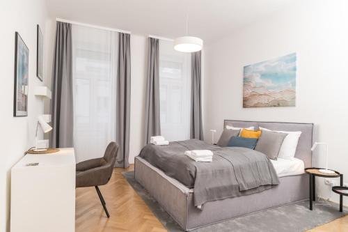 ein Schlafzimmer mit einem Bett und einem Schreibtisch mit einem Stuhl in der Unterkunft Stadlau Live Apartments in Wien