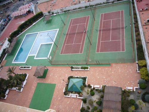 ベニドルムにあるGemelos 2 - Fincas Arenaのテニスコート3面付きのテニスコートのオーバーヘッドビュー