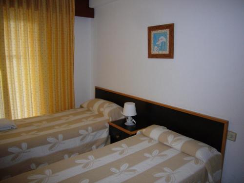 a hotel room with two beds and a lamp at Gemelos 2 - Fincas Arena in Benidorm