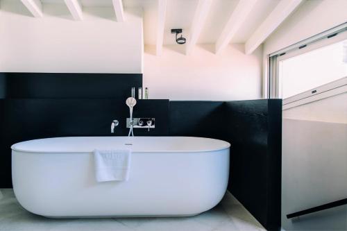 a large white tub in a bathroom with black walls at Sant Francesc Hotel Singular in Palma de Mallorca