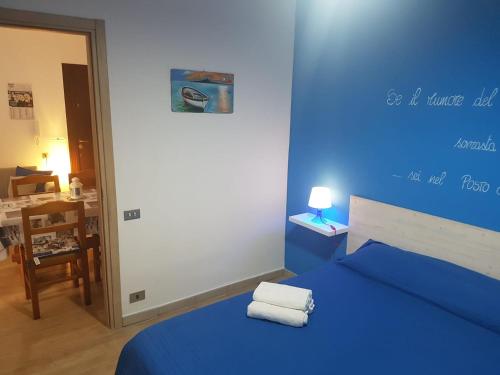 1 dormitorio azul con 1 cama con 2 toallas en Casa Vacanze Trinacria en Isola delle Femmine