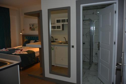 uma casa de banho com um espelho e um quarto com uma cama em THE NORDİC HOTEL em Kemer