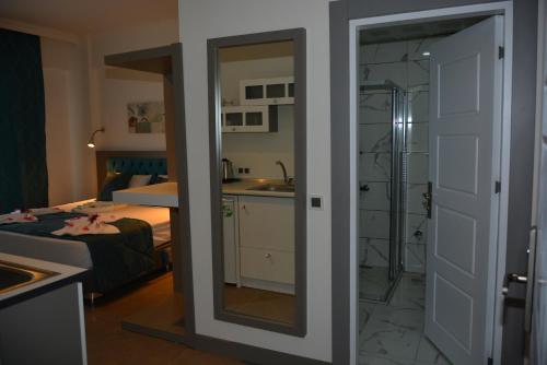 a bathroom with a mirror and a bedroom with a bed at THe NORDİC HOTEL in Kemer