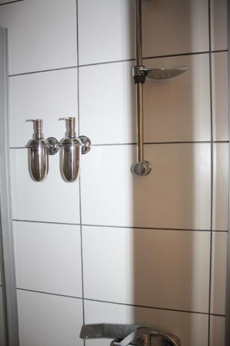 a shower with two pots on a tiled wall at Pi Art Butik Otel in Istanbul