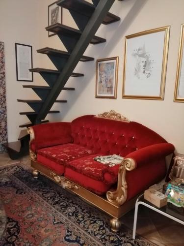 a red couch in a living room with a staircase at Holiday Home Zolfare in Comitini
