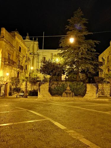 a street at night with a tree and a building at Holiday Home Zolfare in Comitini