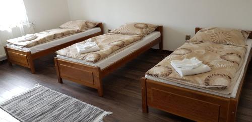 two twin beds in a room with wooden floors at Apartman Zatura in Vyšná Šuňava