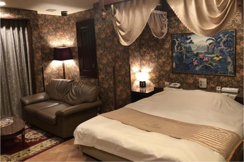 a bedroom with a bed and a couch at ホテルメイフェア Adult Only 男塾ホテルグループ in Yōkaichi