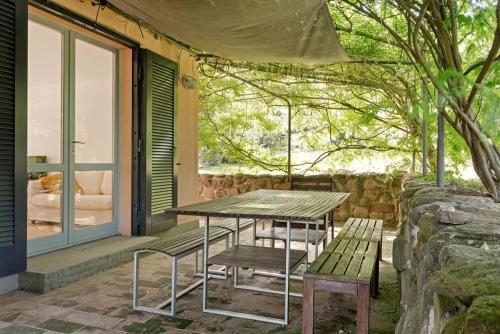 a picnic table and bench on the porch of a house at Casali Marchigiani - Ville vacanza private con piscina in Ostra