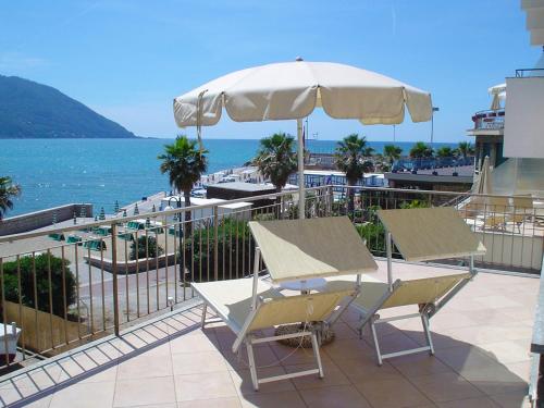 a patio with two chairs and an umbrella and the ocean at Hotel Elena in Recco