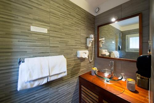 une salle de bain avec un lavabo et un miroir dans l'établissement Les Terrasses de Saumur - Hôtel & Appartements - Restaurant & Spa (Logis), à Saumur