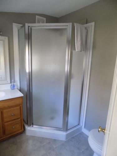a shower in a bathroom with a sink and a toilet at Wilderness Inn Bed and Breakfast in North Woodstock