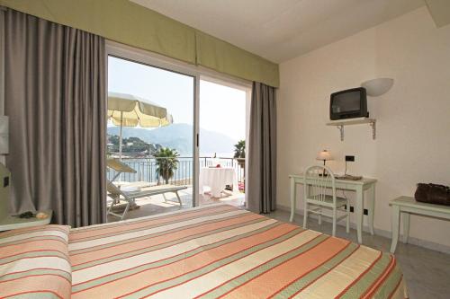 Hotel Elena في ريكو: غرفه فندقيه بسرير وشرفه