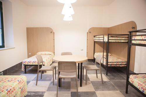 a room with a table and chairs and bunk beds at Ostello Alfieri 2 in Turin