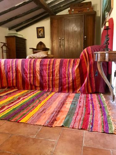 a bed with a colorful blanket on top of it at Borgo Vecchio in Carbognano