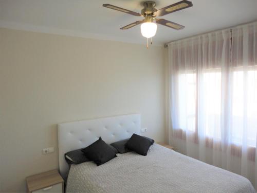 a bedroom with a bed with a ceiling fan at Lamoga-Sandi 4 2 in Torredembarra