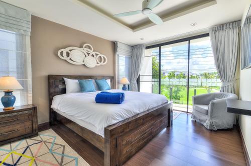 1 dormitorio con cama grande y ventana grande en 4BDR Pool Villa In Laguna Park #45, en Bang Tao Beach