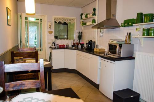 cocina con armarios blancos y encimera en Vakantiewoning De Berkeboom, en Winterswijk