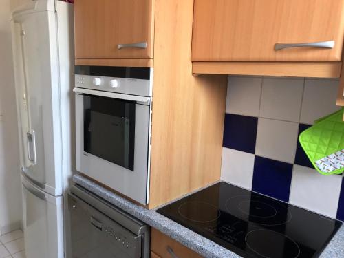 une cuisine avec une cuisinière et un réfrigérateur dans l'établissement Appartement 3 chambres avec roof top à 5 mn de la plage, à Deauville