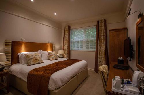 a bedroom with a large bed and a window at Briery Wood Hotel in Ambleside