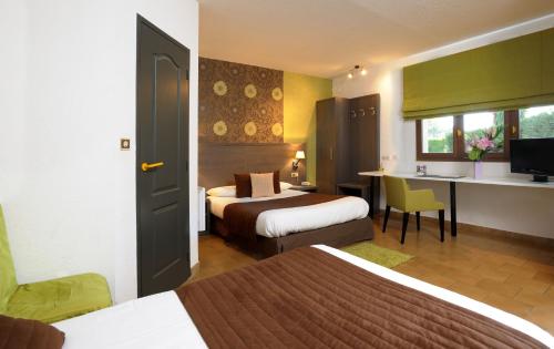 a hotel room with two beds and a desk at Logis Le Mistral - Montélimar Sud in Châteauneuf-du-Rhône