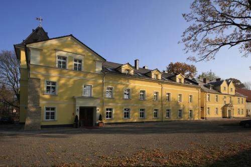 un gran edificio amarillo con muchas ventanas en Pałac Lucja, en Zakrzów