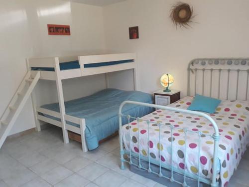- une chambre avec un lit superposé à côté d'un couvre-lit superposé dans l'établissement UN COIN DE PROVENCE ,LA Maison D'ANTOINE, à La Roque-sur-Pernes
