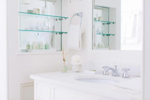 a white bathroom with a sink and a mirror at Zero George Hotel in Charleston