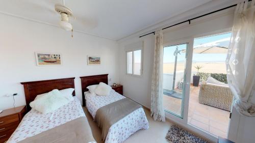 two beds in a bedroom with a view of the ocean at Marrajo 287334-A Murcia Holiday Rentals Property in Roldán