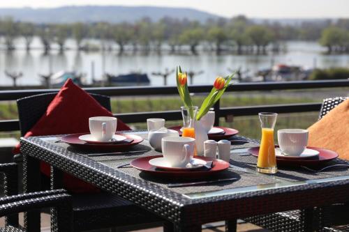 a table with plates and cups and flowers on it at Nägler´s Fine Lounge Hotel in Oestrich-Winkel