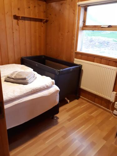 ein Schlafzimmer mit einem Bett in einem Zimmer mit einem Fenster in der Unterkunft Skjaldvararfoss sumarhús in Múli