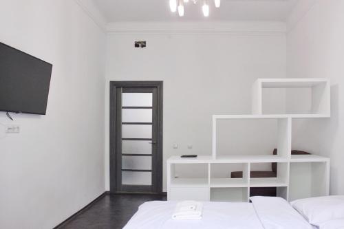 Habitación blanca con 2 camas y TV. en Квартира по вулиці Голубовича 42 біля вокзалу комфортна повноцінна стильна en Leópolis