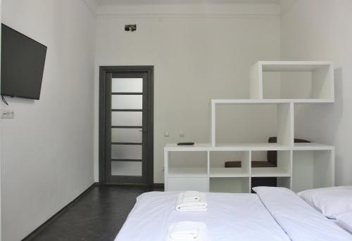 リヴィウにあるКвартира по вулиці Голубовича 42 біля вокзалу комфортна повноцінна стильнаの白いベッドルーム(ベッド1台、テレビ付)