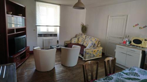 sala de estar con sofá y silla en Gite pour 6 ou chambre pour 2 à FORMIGNY, en Formigny