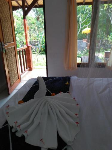 a bedroom with a bed with a swan on it at Taman Menjangan homestay by SnorkelingMenjangan in Banyuwedang