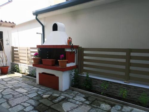 a backyard with a bird feeder on the side of a house at Dimitra's Apartments in Olympiaki Akti