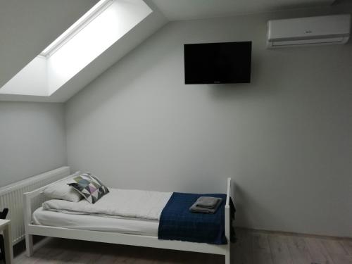 a bedroom with a bed and a tv on the wall at Pokoje pod Baranami Zator Przeciszów in Przeciszów