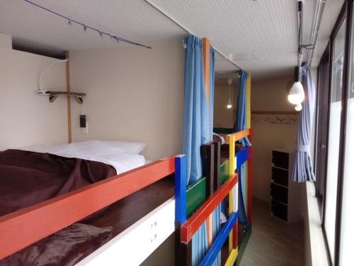 a bedroom with a bunk bed with colorful railings at Asahikawa Ride in Asahikawa