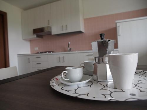 una mesa con dos tazas y una cafetera en ella en Alloggio Agrituristico Ai Tre Castelli, en Moruzzo