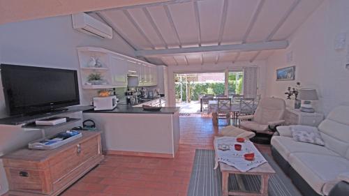 un salon avec un canapé et une télévision et une cuisine dans l'établissement Bleuets d'Azur, à Sainte-Maxime