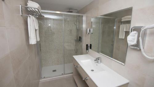 a bathroom with a shower and a sink and a mirror at Hotel Chevy & Suites in Cala Ratjada