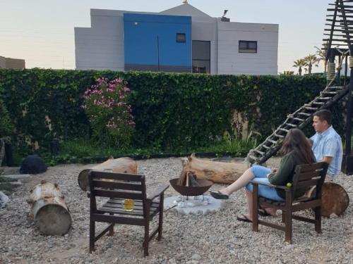 a man and woman sitting in chairs in a yard at Crayfish Creek in Langstrand