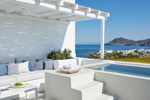 a living room with a white couch and a view of the ocean at Milos Breeze Boutique Hotel in Pollonia