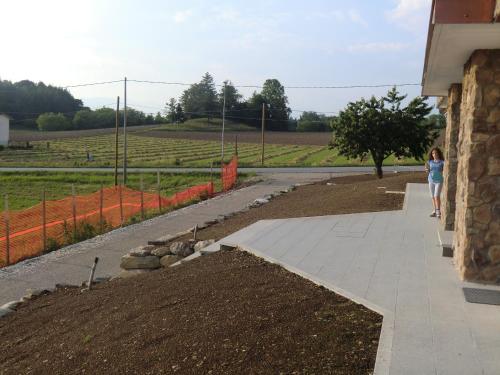 a woman walking down a sidewalk next to a garden at Alloggio Agrituristico Ai Tre Castelli in Moruzzo