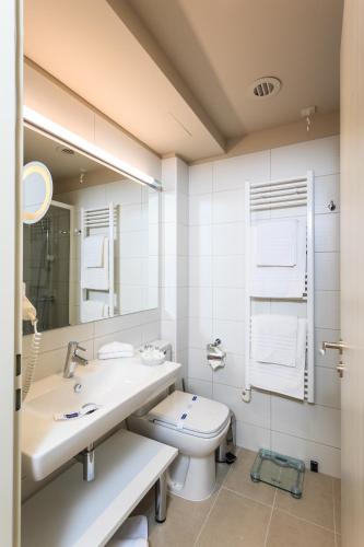 a bathroom with a sink and a toilet and a mirror at Carmen International Hotel Venus - Fost Becali Hotel in Venus