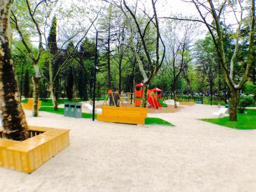 a park with a playground with slides and play equipment at Villa Garden in Tbilisi City