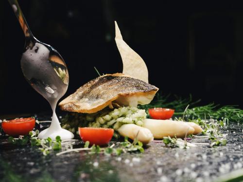 a spoon picking up a piece of food with vegetables at Hotel Bergkristall Zillertal - Adults Only in Hippach
