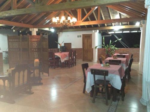 a dining room with tables and chairs and a chandelier at Hotel La Coqueta in Montenegro