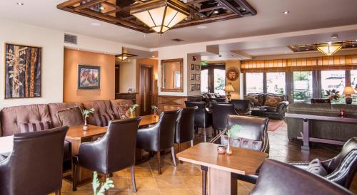 a restaurant with leather chairs and tables and a piano at Selestina Boutique Hotel in Karpenision